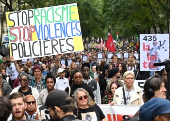 PENUNJUK perasaan memegang sepanduk membantah keganasan polis ketika menyertai perarakan di Paris, Perancis.-AFP
