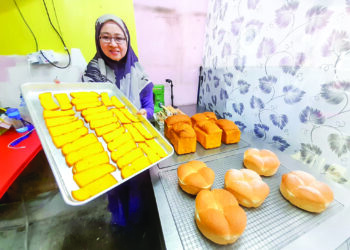 SHAHREEN Jalaluddin menunjukkan roti yang dihasilkan di kedainya di simpang Felda Tenggaroh, Mersing.