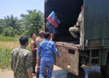 ANGGOTA keselamatan membantu memindahkan mangsa terjejas banjir di Beaufort.-Ihsan APM