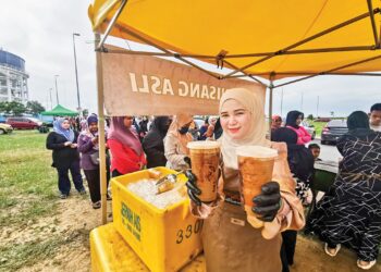 NUR Nadirah Syuhadah Rahmat menyediakan kopi nisang untuk diberikan secara percuma kepada pelanggan di gerainya di Jambatan Angkat Kuala Terengganu, semalam. – UTUSAN/KAMALIZA KAMARUDDIN