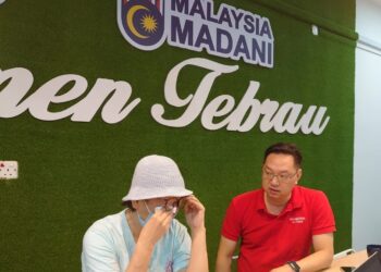 Foo Chi Chin (kiri) bersama Jimmy Puah Wee Tse menunjukkan salinan report polis berhubung ugutan daripada ahlong akibat anak bongsunya yang meminjam wang untuk membeli dadah dan berjudi di Pejabat Khidmat Ahli Parlimen Tebrau, di Taman Gaya, Johor Bahru hari ini.