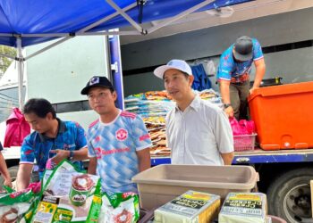 GOOI Hsiao Leung (kiri) menyantuni penduduk Kampung Kebun Sireh, Bukit Tengah dalam program Jelajah Jualan Rahmah, di Bukit Mertajam, Pulau Pinang baru-baru ini.