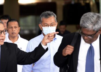AZLAN Man (tengah) hadir di Mahkamah Sesyen Kuala Lumpur bagi sebutan kes tuntutan palsu dan pengubahan wang haram. - UTUSAN/SYAKIR RADIN
