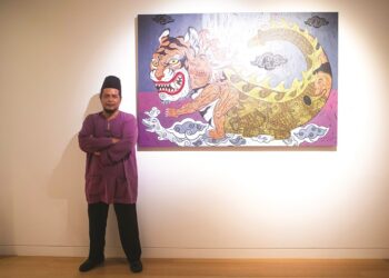 Pelukis Adeputra menerangkan tentang isi yang terdapat di dalam seni karyanya semasa pelancaran pameran Gerak Bayang di Muzium dan Galeri Seni Bank Negara Malaysia, baru-baru ini.  MINGGUAN/AMIN AZMAN