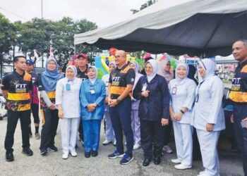 FADZLI MOHAMAD KAMAL (berdiri, kanan) bersama kaki tangan klinik kesihatan dan Jabatan Belia dan Sukan sempena Program Fit Malaysia Pahang di perkarangan parkir Stadium Darul Makmur, Kuantan, Pahang baru-baru ini. – utusan/HARIS FADILAH AHMAD