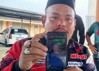 MOHD. NOOR HAMIZI menunjukkan gambar Amir Ruddin Ismail yang maut dalam kemalangan yang turut mengorbankan lima lagi ahli  keluarga di Kilometer 5, Jalan Segamat-Kuantan.