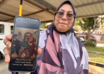 NORHAYATI menunjukkan gambar Noorahimah (kanan) bersama abang serta adik bongsunya ketika ditemui di Jabatan Perubatan Forensik Hospital Segamat, Segamat.