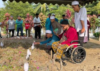 ABDURRAHMAN AMIR RUDDIN ditenangkan bapa saudaranya, Mohamed Khairul Noor Mohamed, 54, pada pengebumian enam ahli keluarganya di Tanah Perkuburan Islam Ubudiah, Parit Limbong, Muar, Johor.