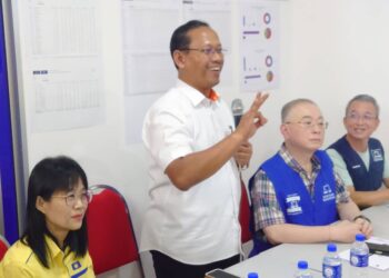 SUHAIZAN KAYAT (berdiri) berucap di hadapan jentera MCA di Taman Perling, Johor Bahru.
