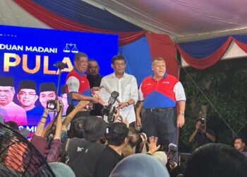 MOHD. IZHAR AHMAD  (tengah) menyerahkan borang keahlian kepada Mohamad Sabu pada Ceramah Mega Perpaduan Madani di Taman Rekreasi Taman Uda Utama, Johor Bahru.