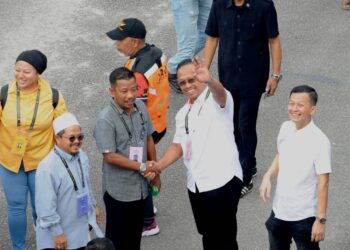 SUHAIZAN KAYAT bersalaman dengan Zulkifli Jaafar ketika mereka meninjau proses pengundian awal di Markas PPM Wilayah Dua, Johor Bahru.