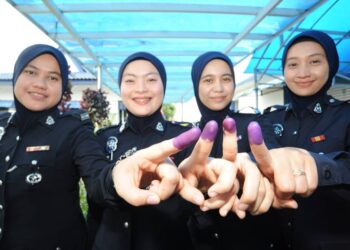ANGGOTA polis wanita menunjukkan jari yang dicelup dakwat selepas mengundi di Markas PPM Wilayah Dua, Johor Bahru.