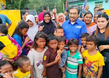 JOHARI ABDUL GHANI meluangkan masa bersama-sama penduduk Orang Asli ketika melawat Kampung Bakar Batu, Perling, Johor Bahru.