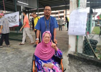ZULKIFLI JAAFAR menemani ibu mentuanya, Montiah Emam yang mengundi di SJKC Tampoi, Johor Bahru.
