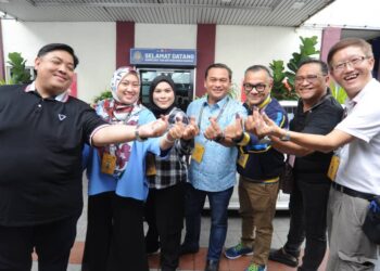 MOHAMAD FAUZI ISHAK (tengah) dan Nur Aisyah (tiga dari kiri) bergambar bersama-sama petugas media yang mengundi pada PRK Parlimen Pulai, hari ini.