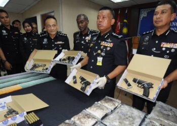 KAMARUL ZAMAN MAMAT (dua dari kanan) dan beberapa pegawai polis menunjukkan senjata api yang berjaya dirampas daripada sindiket pengedaran dadah dalam sidang media di IPK, Johor Bahru.