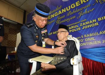 KAMARUL ZAMAN MAMAT menyematkan pingat kepada bekas anggota polis, Awang Daud sempena Istiadat Penganugerahan Pingat Jasa Pahlawan Negara Kontinjen Johor di IPK Johor, Johor Bahru.