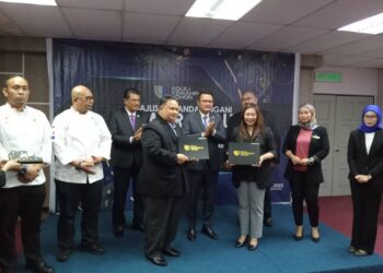 MOHD. HAIRI MAD SHAH (belakang, tengah) menyaksikan majlis menandatangani dan pertukaran MoU antara Kolej Kemahiran Johor dan pemain industri di Hotel Seri Malaysia, Johor Bahru.