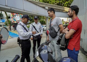 ANGGOTA polis mengeluarkan saman kepada penunggang motosikal warga asing yang melakukan kesalahan jalan raya pada Operasi Hormat Undang-Undang Fasa 2 bermula hari ini sehingga 29 September nanti ketika tinjauan di Persimpangan Jalan Bukit Bintang di sini, hari ini.-UTUSAN/FARIZ RUSADIO