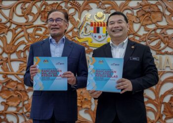 ANWAR Ibrahim (kiri) bersama Rafizi Ramli menunjukkan buku Kajian Separuh Penggal Rancangan Malaysia Ke-12 pada Mesyuarat Khas Sidang Dewan Rakyat hari ini. - UTUSAN/FARIZ RUSADIO