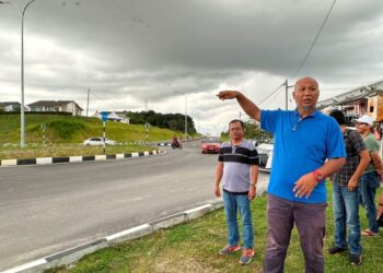 MOHD Syukur Jalinu menunjukkan Jalan Meru Raya-Klebang yang kurang papan tanda dan bonggol jalan di Ipoh. - UTUSAN/LIYANA RAMLI