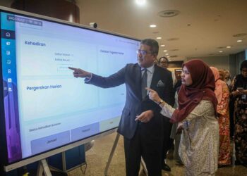 AHMAD Terrirudin Mohd. Salleh menyentuh skrin perakam waktu ketika melaporkan diri pada hari pertama menjalankan tugas sebagai Peguam Negara baharu di Putrajaya, semalam.– UTUSAN/FAIZ ALIF ZUBIR