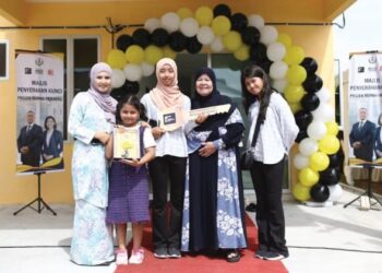 NURUL Indah Ibrahim (kiri) bersama anak-anak dan ibunya pada majlis penyerahan kunci projek Rumah Perakku Taman Serdang, Sitiawan
di Lumut. – UTUSAN/MUHAMAD NAZREEN SYAH MUSTHAFA