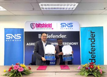 Kelvin Pah (kiri) dan Prabeer Sarkar bertukar dokumen selepas menandatangani perjanjian kerjasama di Kuala Lumpur hari ini.