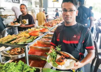 MUHAMMAD Nur Faris Fiza Saufi menunjukkan makanan tengah hari yang disediakan di Pemilik Restoran Udang Galah di Teluk Intan. - UTUSAN/AIN SAFRE BIDIN