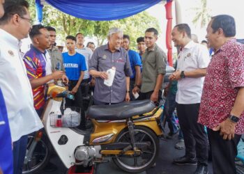 AHMAD ZAHID Hamidi melawat gerai pameran Giat Mara sambil diperhatikan Timbalan Menteri Kewangan I, Datuk Seri Ahmad Maslan dan Menteri Besar Johor, Datuk Onn Hafiz Ghazi pada Majlis Perasmian Penutup Sentuhan Kasih Desa di Sungai Abong, Muar, Johor. - UTUSAN/SHIDDIEQIIN ZON