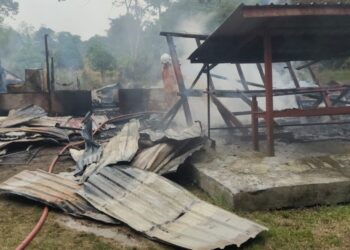 ANGGOTA bomba memadamkan kebakaran sebuah rumah di Kampung Solok, Rembau, petang tadi.-UTUSAN/NOR AINNA HAMZAH.