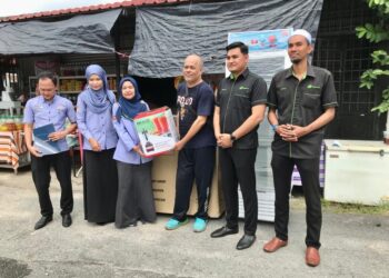 NORA Yaacob (tiga kiri) menyampaikan peralatan perniagaan kepada Kamarudin Mohd. Din di rumahnya di Taman Sabariah, Pengkalan Chepa, Kota Bharu, Kelantan-UTUSAN/ ROSLIZA MOHAMED