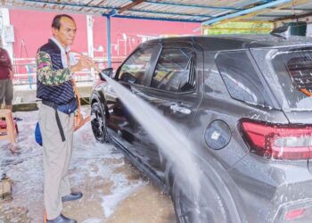 RAMAZAN Abu Samah membersihkan kereta seorang pelanggan di kedainya di Solok Duku, Masjid Tanah, Melaka. – UTUSAN/MUHAMMAD SHAHIZAM TAZALI