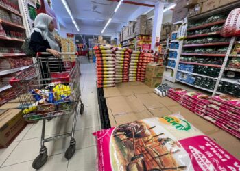 SEORANG pengunjung melihat bekalan beras tempatan yang habis di sebuah pasar raya di Gua Musang, Kelantan. - UTUSAN/AIMUNI TUAN LAH