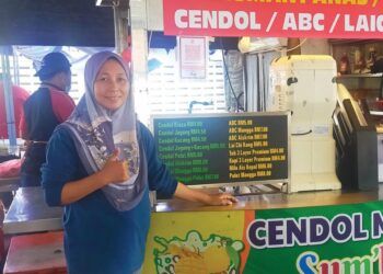 Rahimah Rusni di depan gerai cendolnya Cendol Sawit Sum’beso di Sungai Besar, Sabak Bernam.