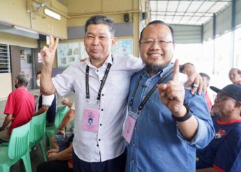 NAZRI Abdul Rahman (kiri) dan Mohd. Mazri Yahya beramah mesra ketika bertemu di SJKC Pei Chai, Muar, Johor. - UTUSAN/SHIDDIEQIIN ZON
