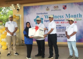 HILMI Abdullah (tengah) menyampaikan hadiah cabutan bertuah kepada seorang peserta pada Majlis Perasmian Sambutan Wellness Month Peringkat Negeri Kelantan 2023 di Dataran Bandar Baru Lubok Jong, Pasir Mas, Kelantan. UTUSAN/ROSMIZAN RESDI