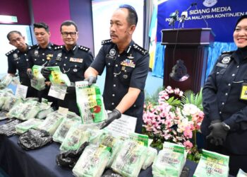 JAUTEH Dikun (dua kanan) menunjukkan dadah yang dimasukkan dalam bungkusan teh Cina dalam sidang akhbar di Kota Kinabalu hari ini
