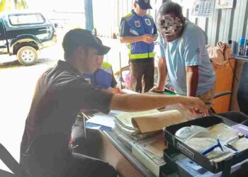 KAMPIT beras tempatan yang digunakan untuk membungkus beras import oleh seorang pemborong beras di Pekan Teroi, Guar Chempedak di Yan.