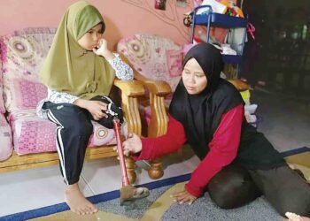 SHUHAILA Norasmira Mohd. Shukri menunjukkan kaki palsu anaknya, Nor Dhia Dhalieya Mohamad Nor yang rosak ketika ditemui di kediamannya di Kampung Bukit Merah, Paka, Dungun, semalam. – UTUSAN/NIK NUR IZZATUL HAZWANI NIK ADNAN
