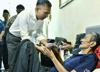FAHMI Fadzil menyampaikan bantuan ketika menziarahi penerbit rancangan Radio Televisyen Malaysia (RTM), Irwan Budi Annuar, 49, yang menghidap masalah kesihatan di kediamannya di Jalan Bako, Petra Jaya di sini hari ini.