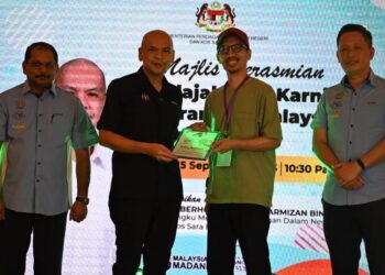ARMIZAN Mohd. Ali (dua kiri) menyampaikan sijil penyertaan kepada salah seorang peserta pameran yang mengambil bahagian dalam Mini Karnival Barangan Malaysia di Kota Kinabalu hari ini.