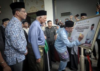 ANWAR Ibrahim menandatangani plak pelancaran pada Majlis Solidariti Wakaf Sejuta Al-Quran di Kompleks Nasyrul Quran, Putrajaya di sini, hari ini.-UTUSAN/FAIZ ALIF ZUBIR