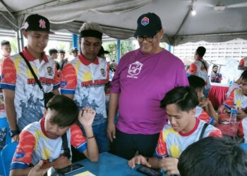 JEFRIDIN Atan ( berdiri kanan) melihat acara e- sukan sempena Sambutan Hari    Hari Malaysia DUN Kukup  di Komplek Penghulu Mukim Serkat, di Pontian, disini, hari ini.