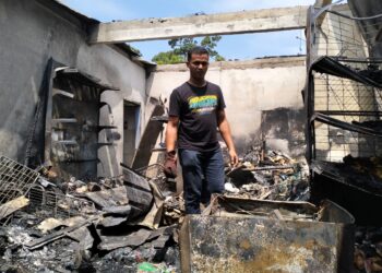 SAFUAN Mohd. Nordin melihat keadaan kedai runcit milik isterinya yang terbakar di Kampung Teliar, Bunut Susu, Pasir Mas, Kelantan-UTUSAN/ROHANA ISMAIL.