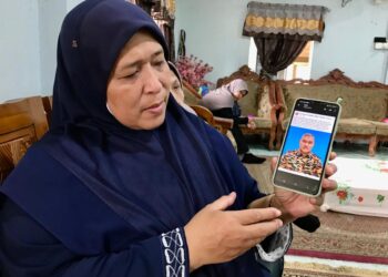 SALAH seorang ahli keluarga menunjukkan gambar Mohd. Syukri yang maut dalam kemalangan ketika ditemui pemberita di rumahnya di Kuala Krai, Kelantan hari ini-UTUSAN/ROSLIZA MOHAMED.