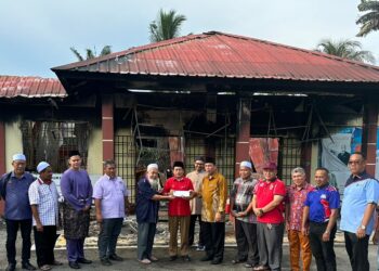 AHMAD Maslan (tengah) menyampaikan sumbangan kepada Sekolah Menengah Agama Bugisiah Tampok Benut yang terlibat dengan kebakaran, di Pontian, disini, pagi ini.