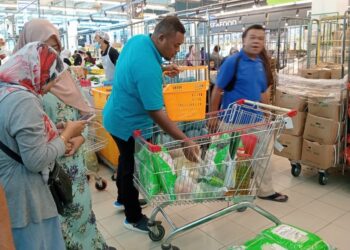 Seorang pelanggan membeli kampit beras import dalam Jualan Rahmah di pasaraya Target di IOI Kulai, Kulai
