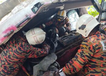 ANGGOTpasukan  Bomba dan Penyelamat Kluang, mengeluarkan mayat Jasman Ghazali yang tersepit di tempat duduk pemandu lori dipandunya selepas terbabas di kilometer 87 Jalan Batu Pahat - Mersing pagi tadi.