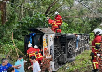 ANGGOTA Bomba membantu mengeluarkan mangsa dari sebuah bas persiaran yang terbabas dan terbalik dalam kemalangan di Kampung Baru Si Rusa, Port Dickson pagi tadi.-GAMBAR/IHSAN BOMBA